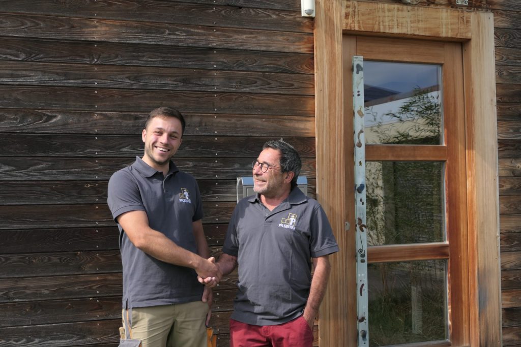 Neuer Geschäftsführer Luca Pfleiderer und alter Geschäftsführer Axel Pfleiderer reichen sich die Hand.