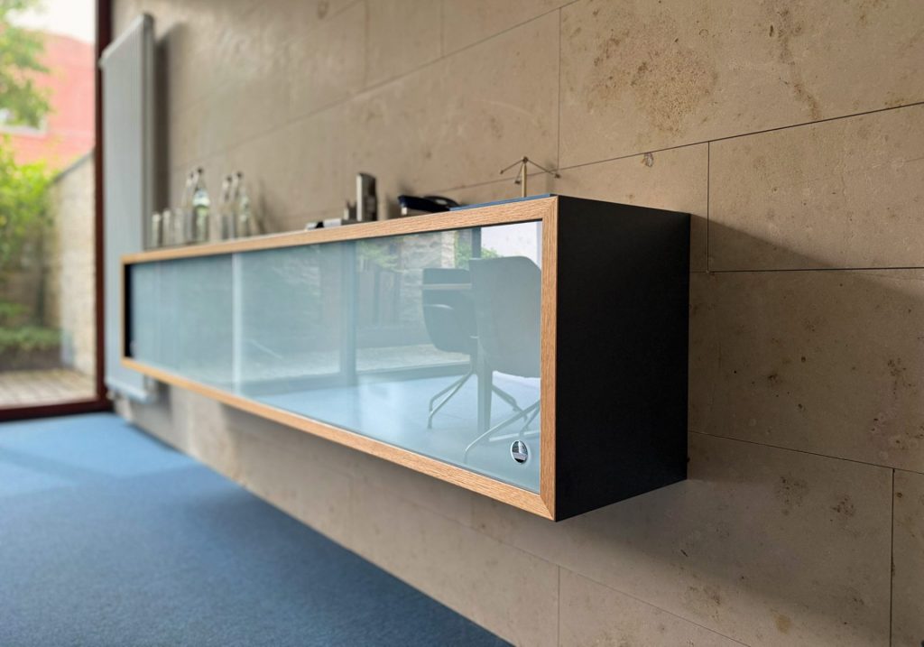 Hängesideboard mit dunklen fronten und einer Glastür.