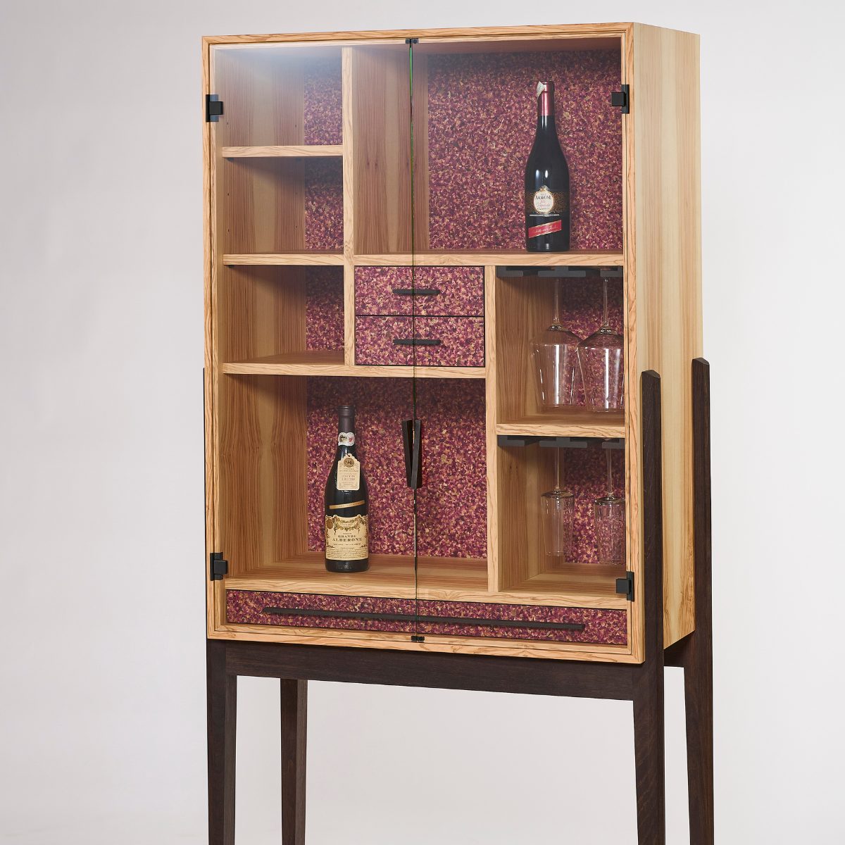 Hochwertiger Olivenholz‑Barschrank mit Barfach aus geräucherter Eiche, zwei ausziehbaren Schubladen und dekorativen Fronten aus gepressten Rosen.