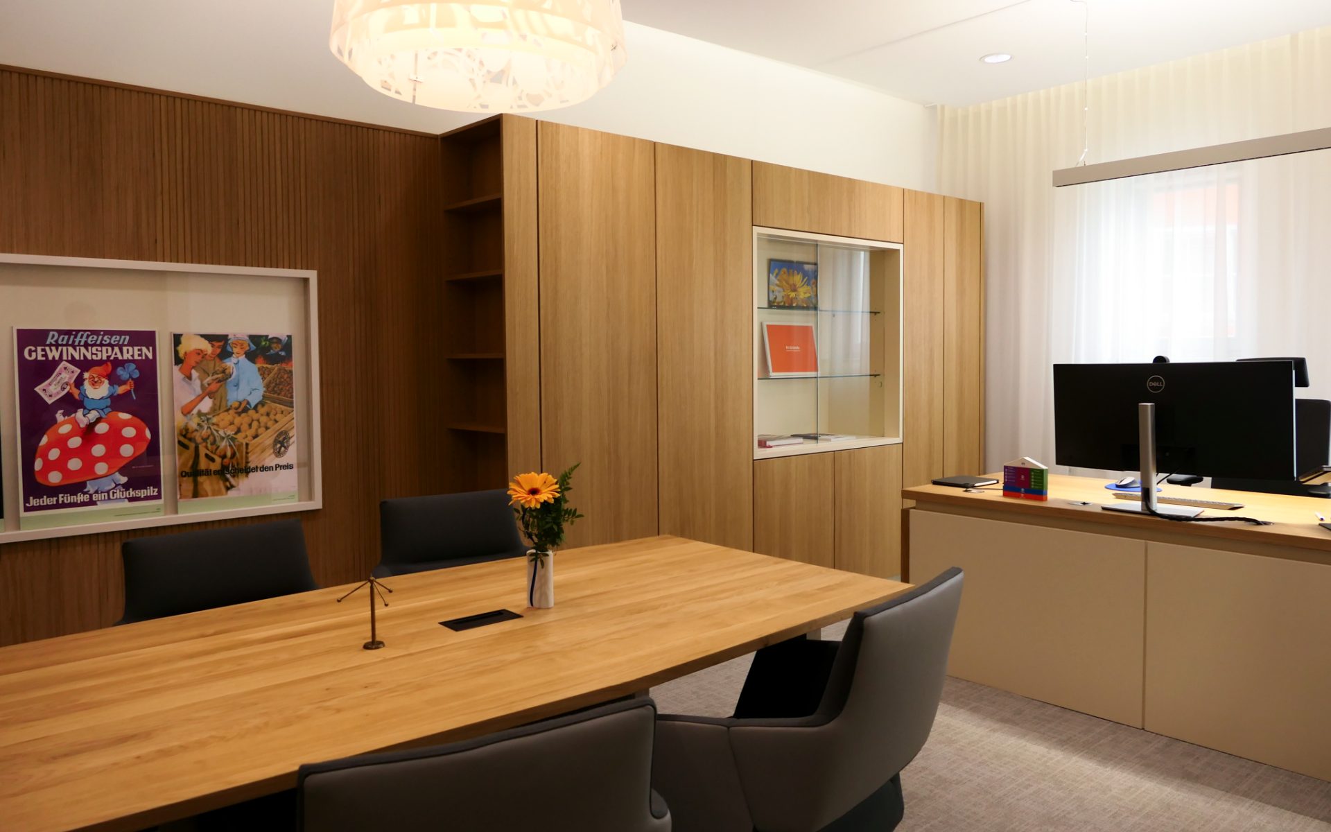 Modernes Bank‑Besprechungszimmer mit heller Eichenholz‑Wandverkleidung, einem großen Tisch aus massiver Eiche und vier eleganten grauen Stühlen, die eine warme und professionelle Atmosphäre schaffen