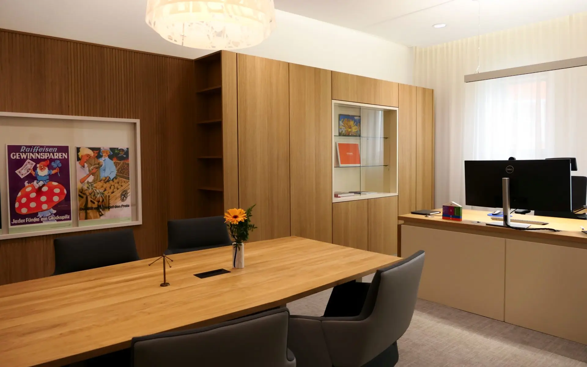 Modernes Bank‑Besprechungszimmer mit heller Eichenholz‑Wandverkleidung, einem großen Tisch aus massiver Eiche und vier eleganten grauen Stühlen, die eine warme und professionelle Atmosphäre schaffen