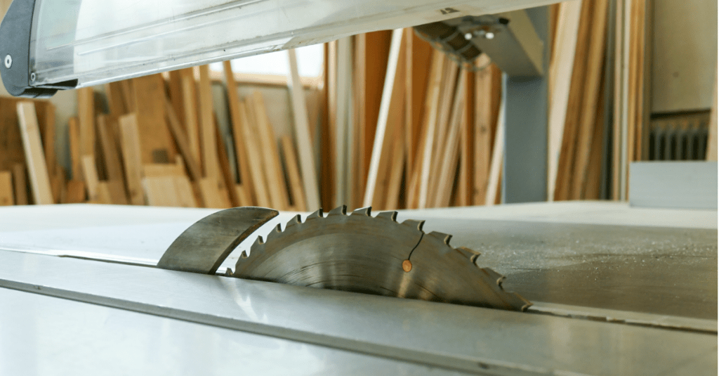 Säge in einer Werkstatt mit sauber sortierten Holzarten an der Wand, typische Umgebung einer modernen Schreinerei.
